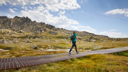 A woman walking wearing a backpack as part of a rucking workout