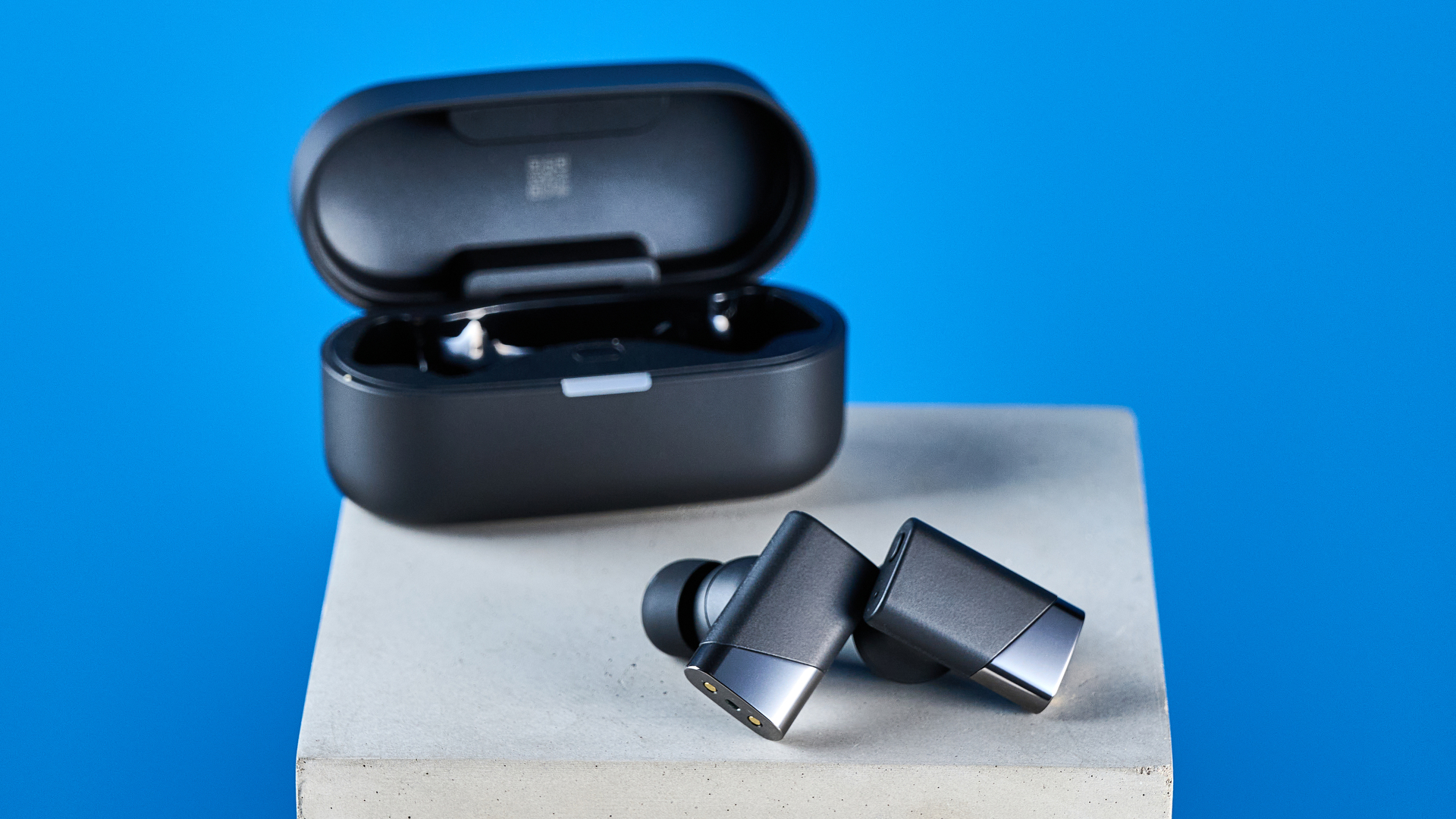A pair of black Status Pro X wireless earbuds