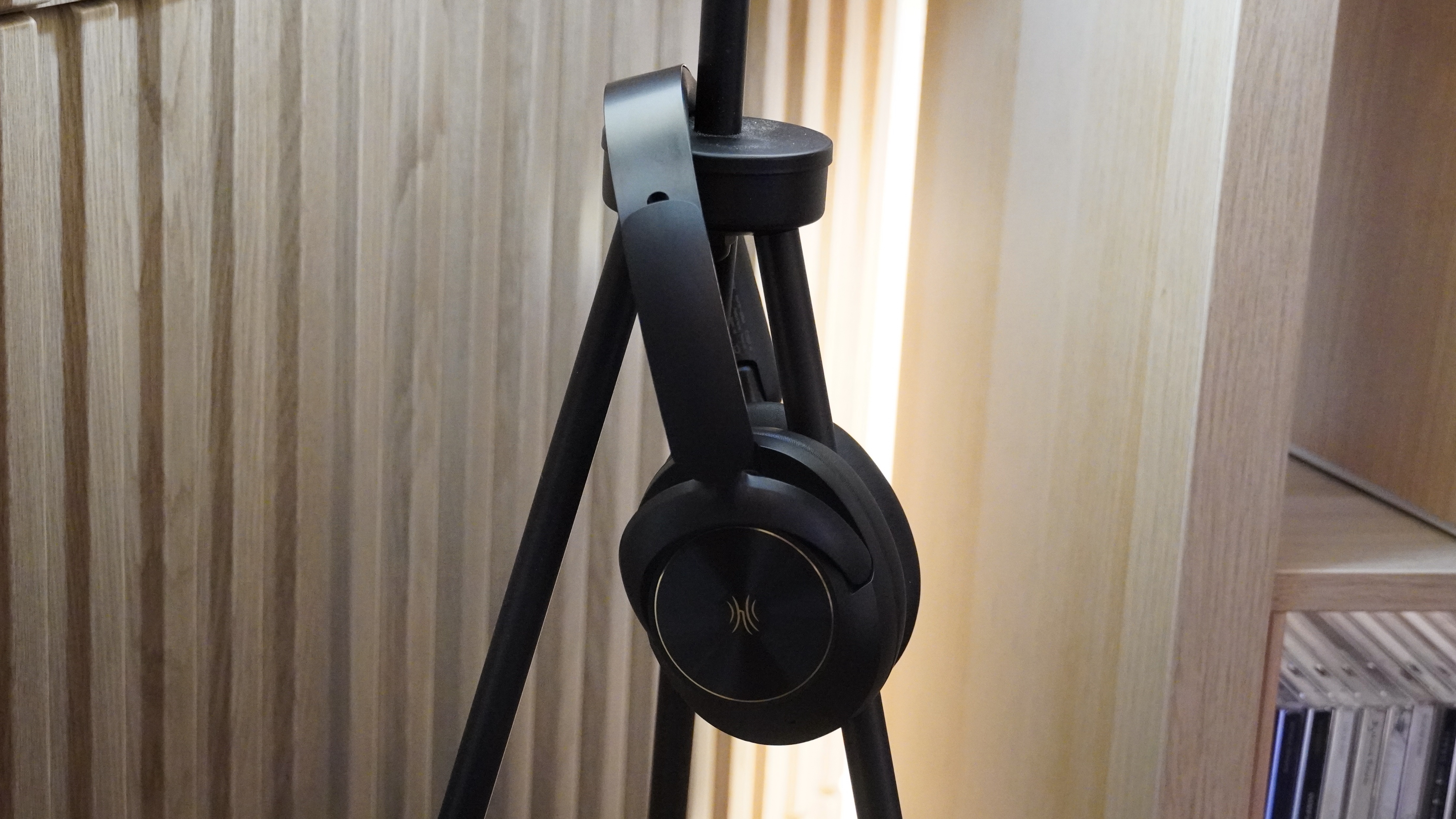 The OneOdio Focus A6 headphones hanging from a light and speaker.