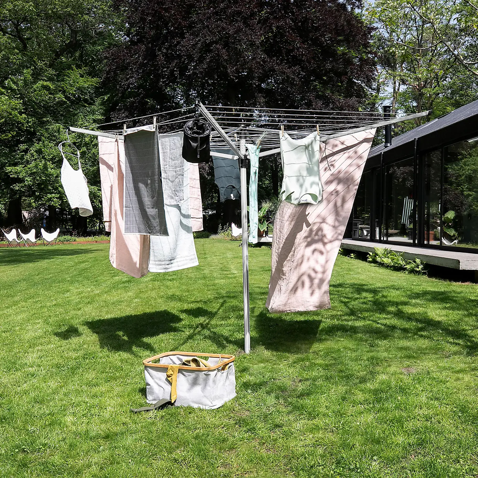 The Brabantia Lift-O-Matic rotary airer with washing hanging on it positioned in a garden lawn