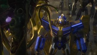 A blue and gold sentient robot looks up at a tentacled robot