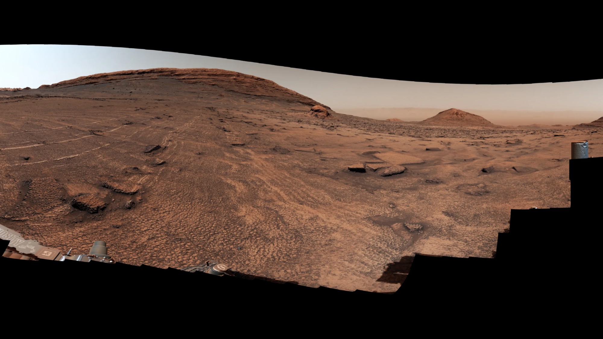 a reddish-brown landscape of soil and rocks covered in slightly raised hexagonal lines of nearly equal size