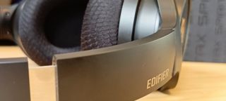 A pair of black Edifier Stax Spirit S3 headphones on a wooden desk