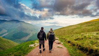 Two men pictured from the rear, walking along a hiking path on Ben Nevis in Scotland