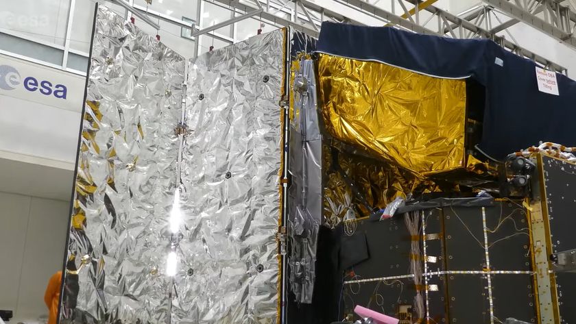 a cube-shaped spacecraft with two wing-like solar panels covered in silver foil