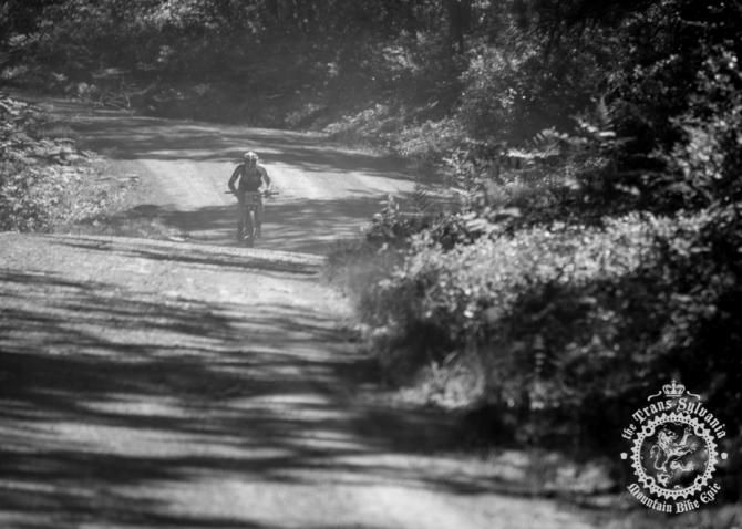 Justin Lindine descends a dusty gravel road before turning into singletrack