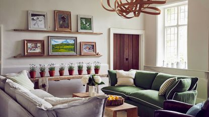 living room with green and cream sofa and display of plant pots with lavender in a line on a bench and bentwood light fitting