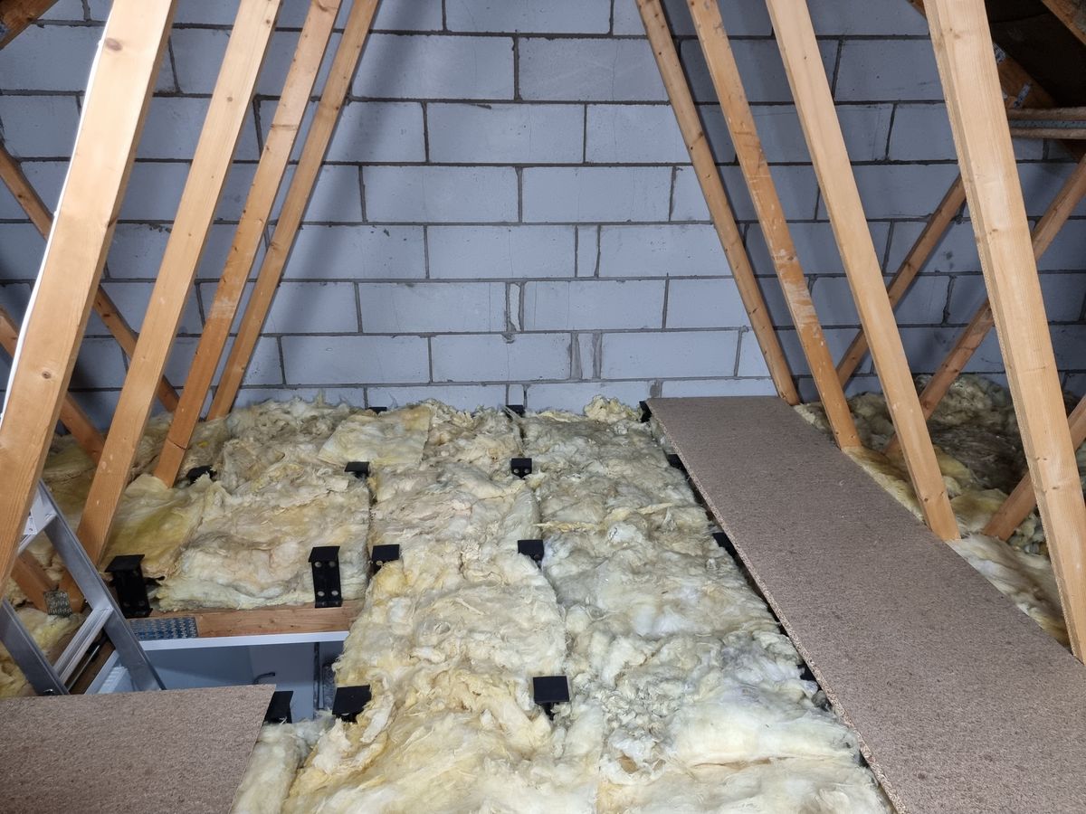 A loft filled with insulation being prepared for a raised floor