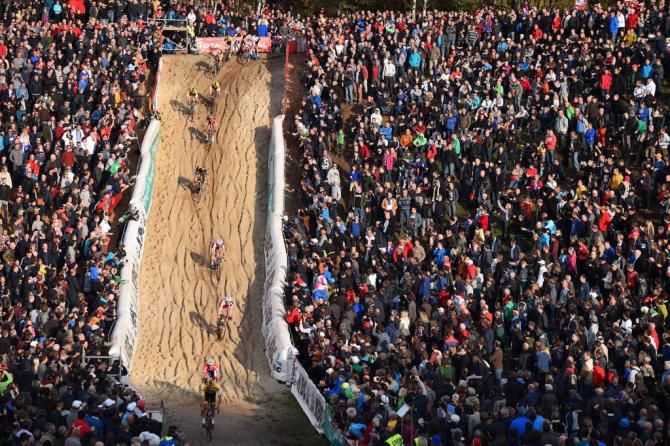 A single line of riders head down the sandy descent