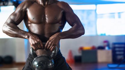 Best kettlebell: Pictured here, a muscular person lifting up a kettlebell in front of his chest