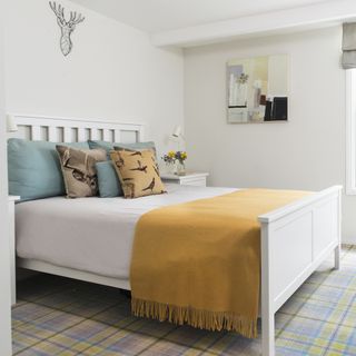 white bedroom with blue and yellow plaid carpet