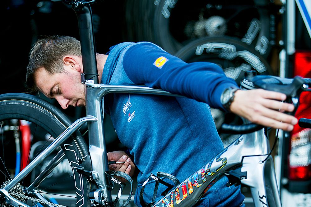 An Etixx-QuickStep mechanic works on a race machine.
