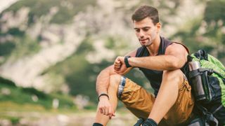 Man in hiking gear checking smartwatch