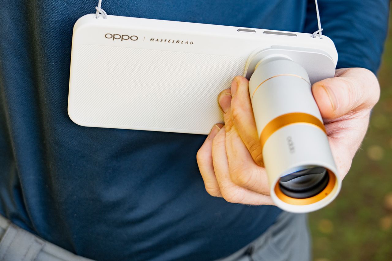 Oppo Find X10 Pro Max phone in user's hand, with 300mm teleconverter lens attached