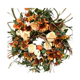 A fall wreath with sunflowers, roses, pumpkins, and green leaves on it