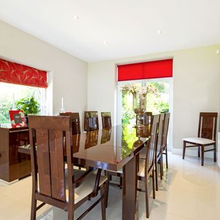 dining room with white wall and wooden dining table with chairs