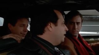 Nic Cage driving and looking irritated at Dana Carvey and Jon Lovitz, Trapped in Paradise (1994).