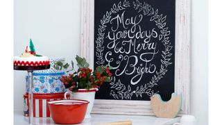 Chalkboard sign with festive message on a kitchen countertop as a creative Christmas decorating idea