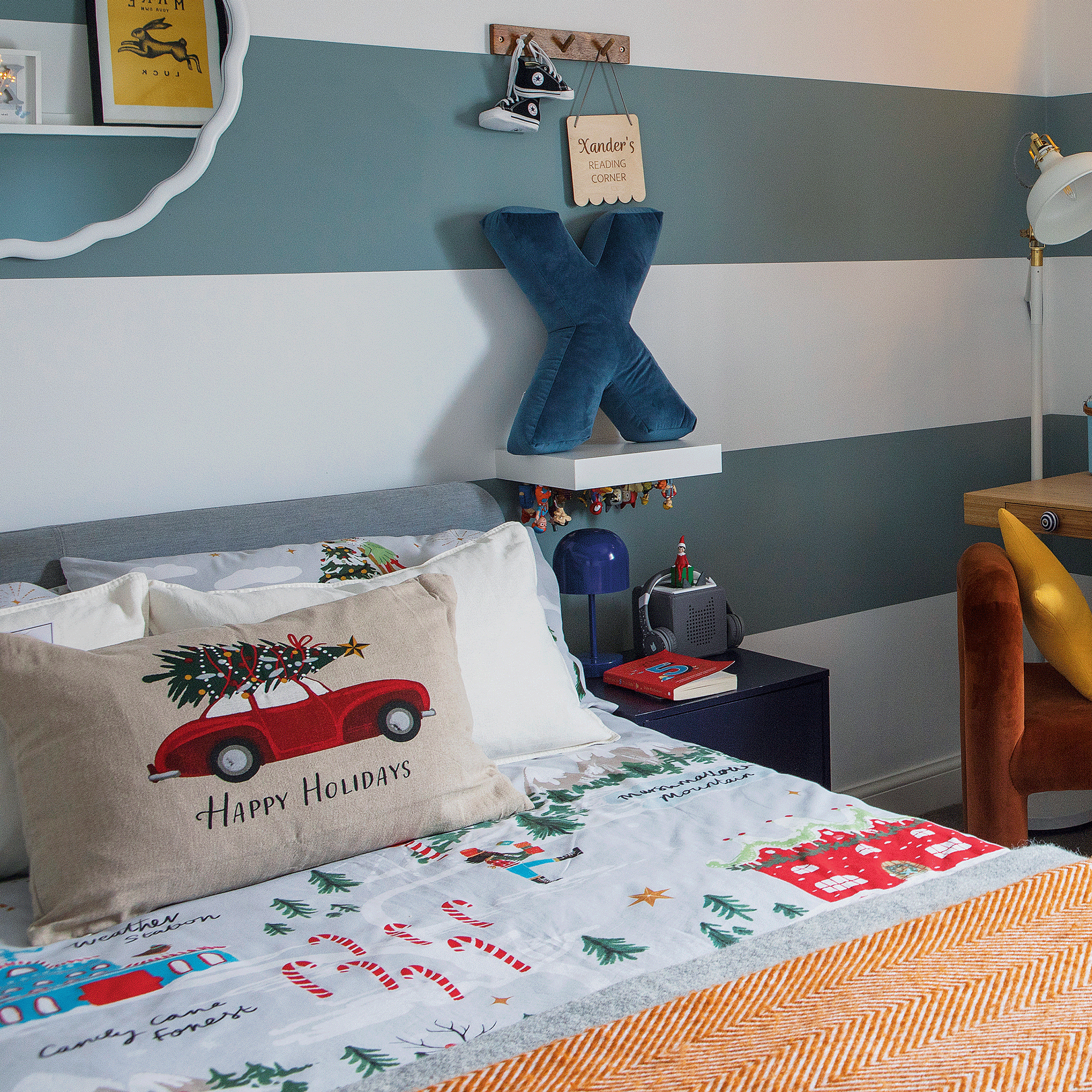 a child's bedroom with a blue and white striped wallpaper and festive bedding