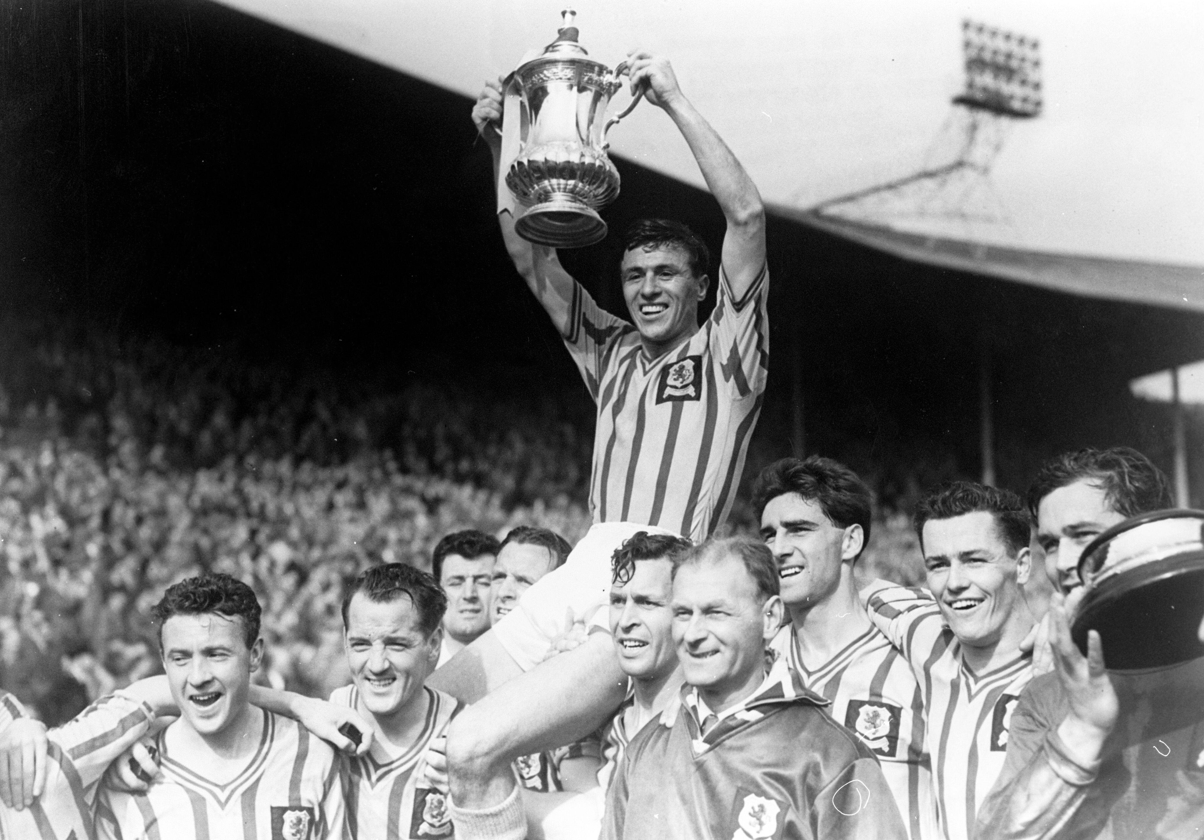 Aston Villa captain Johnny Dixon celebrates with the FA Cup after victory over Manchester United in the 1957 final at Wembley