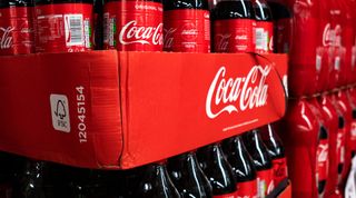 closeup shot of Coca-Cola bottles displayed in store