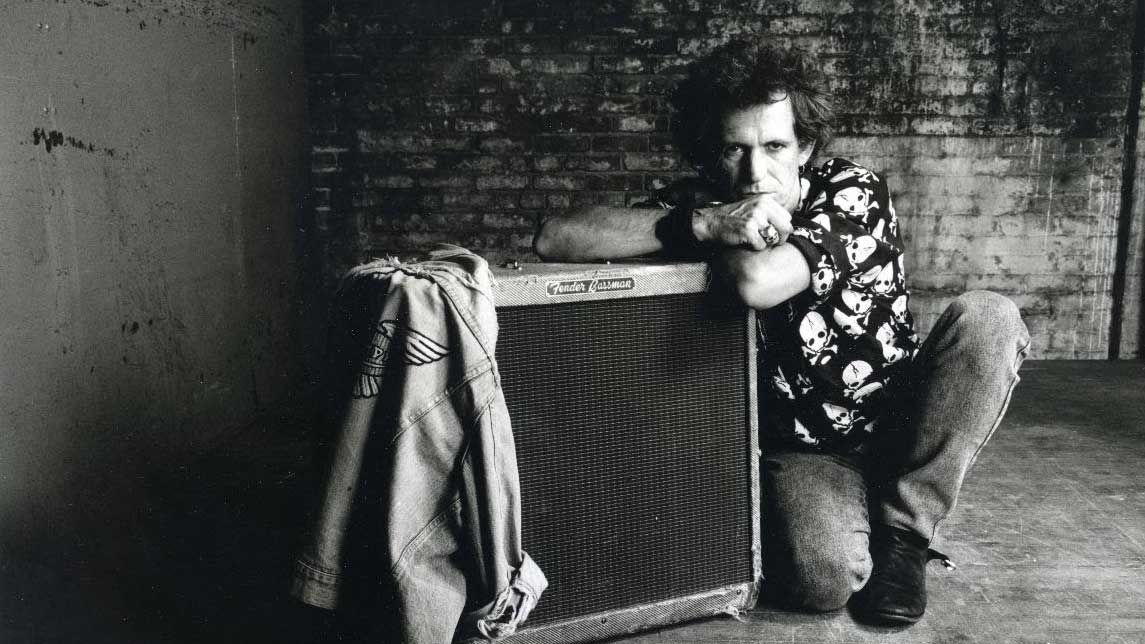 Keith Richards crouching down next to an amplifier