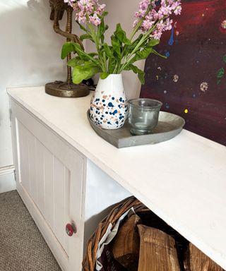 white cabinet with space for log basket built into alcove