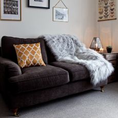A living room with a dark brown suede sofa