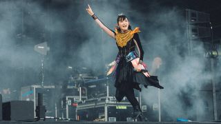 Babymetal smiling and throwing the horns