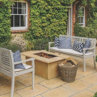 Large patio with a firepit and two garden benches either side