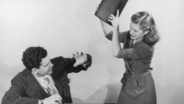 Woman hitting man with book