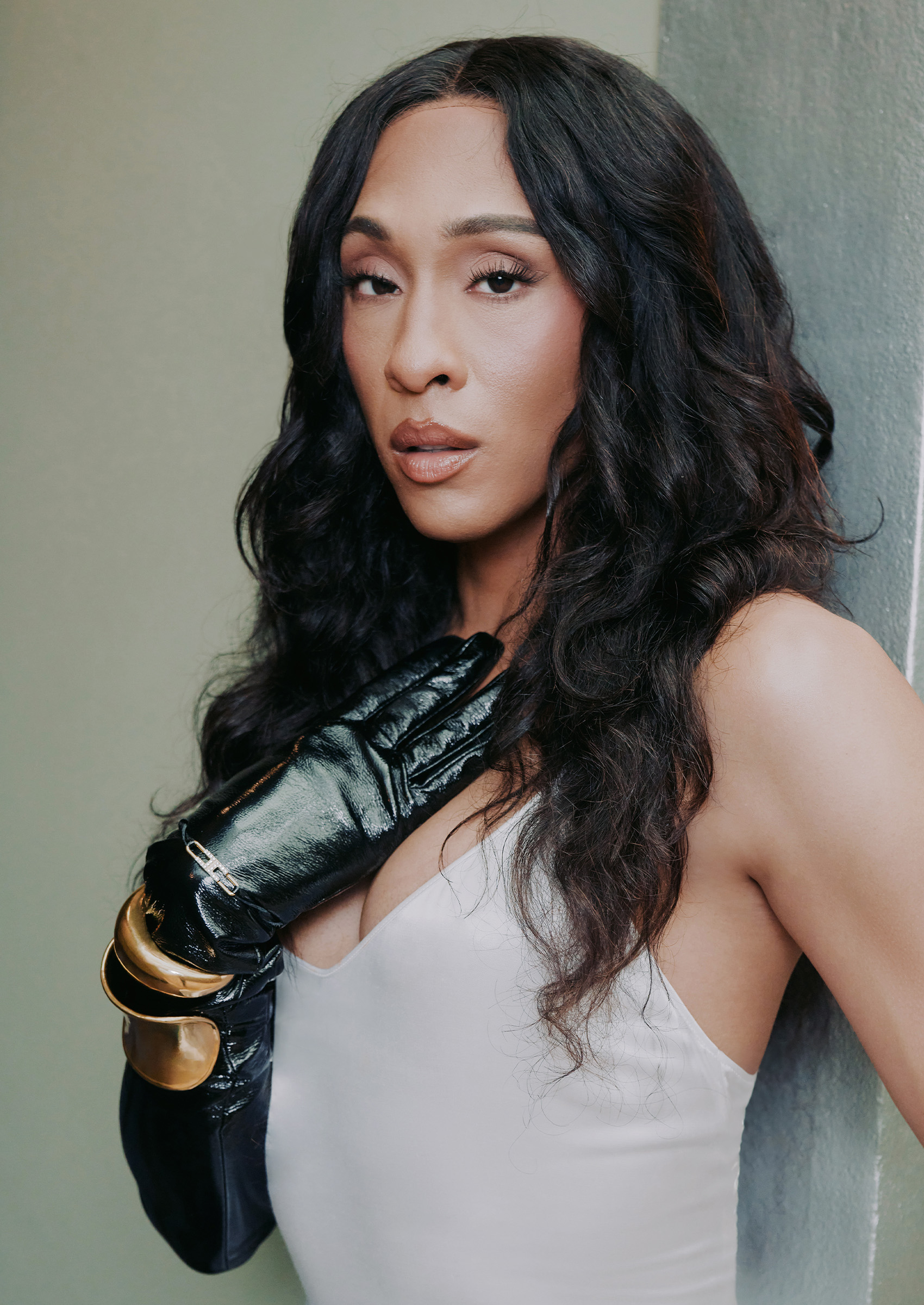 headshot of michaela jae rodriguez wearing a black glove and holding it to her chest