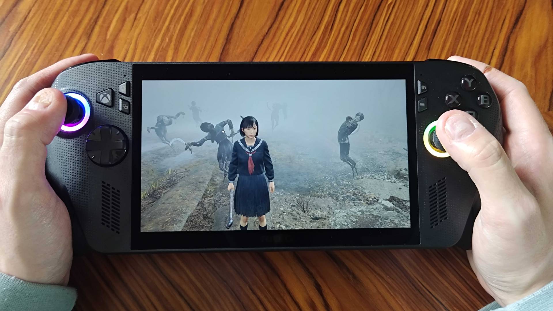 Hands holding ROG Xbox Ally X with Silent Hill F gameplay on screen.