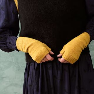 woman wearing yellow Brora cashmere wrist warmers