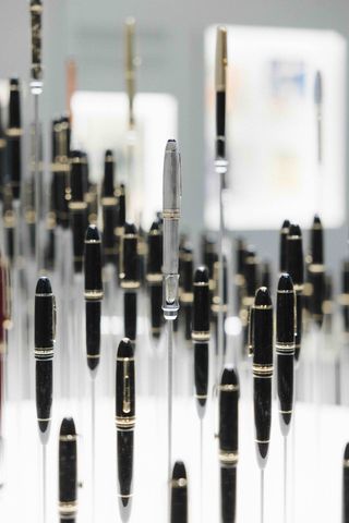 Image of a black and gold fountain pen reflected into multiple versions in a blurred mirrored background