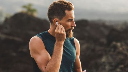 Why are so many sports earbuds wireless? Image shows man wearing earbuds