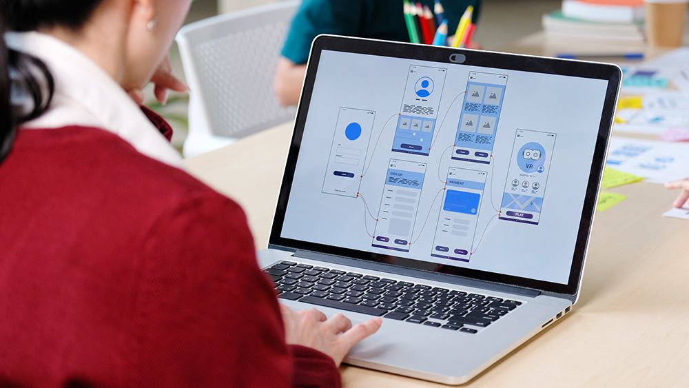 A UI designer uses one of the best UI prototyping tools on a laptop