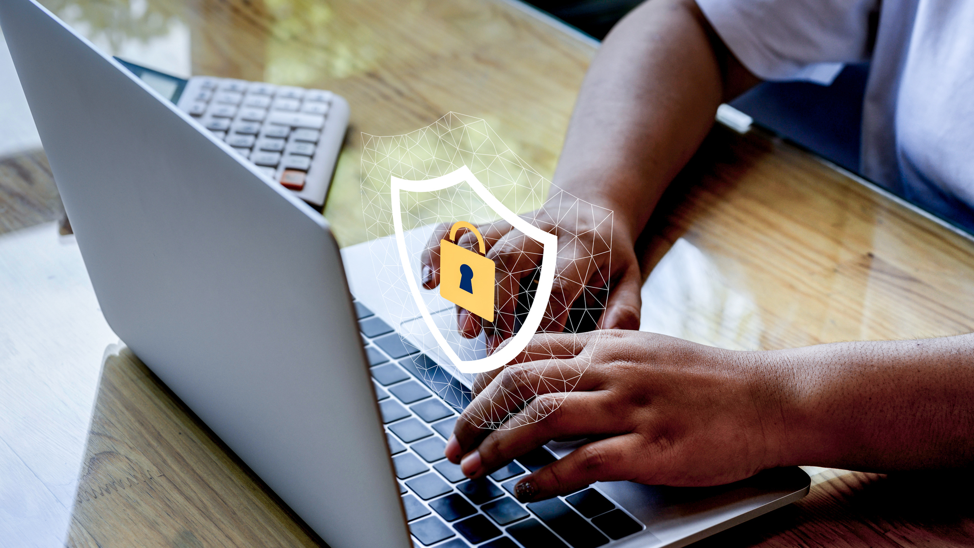 Hands typing on a laptop computer with a lock icon