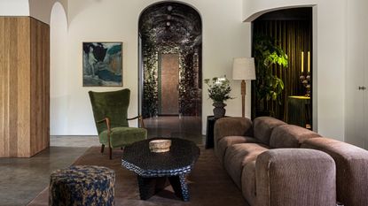 living room with a brown couch, green chair, and earth colored décor 