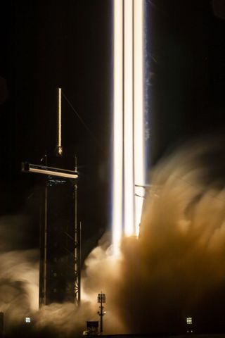 three streaks of solid fire trail behind a rocket taking off
