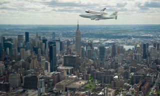 Space shuttle Enterprise, mounted atop a NASA 747 Shuttle Carrier Aircraft (SCA), is seen as it flies near the Empire State Building, Friday, April 27, 2012, in New York.