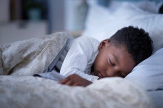 A young boy asleep in bed