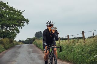 Female cyclist drinking from a water bottle on a bike ride