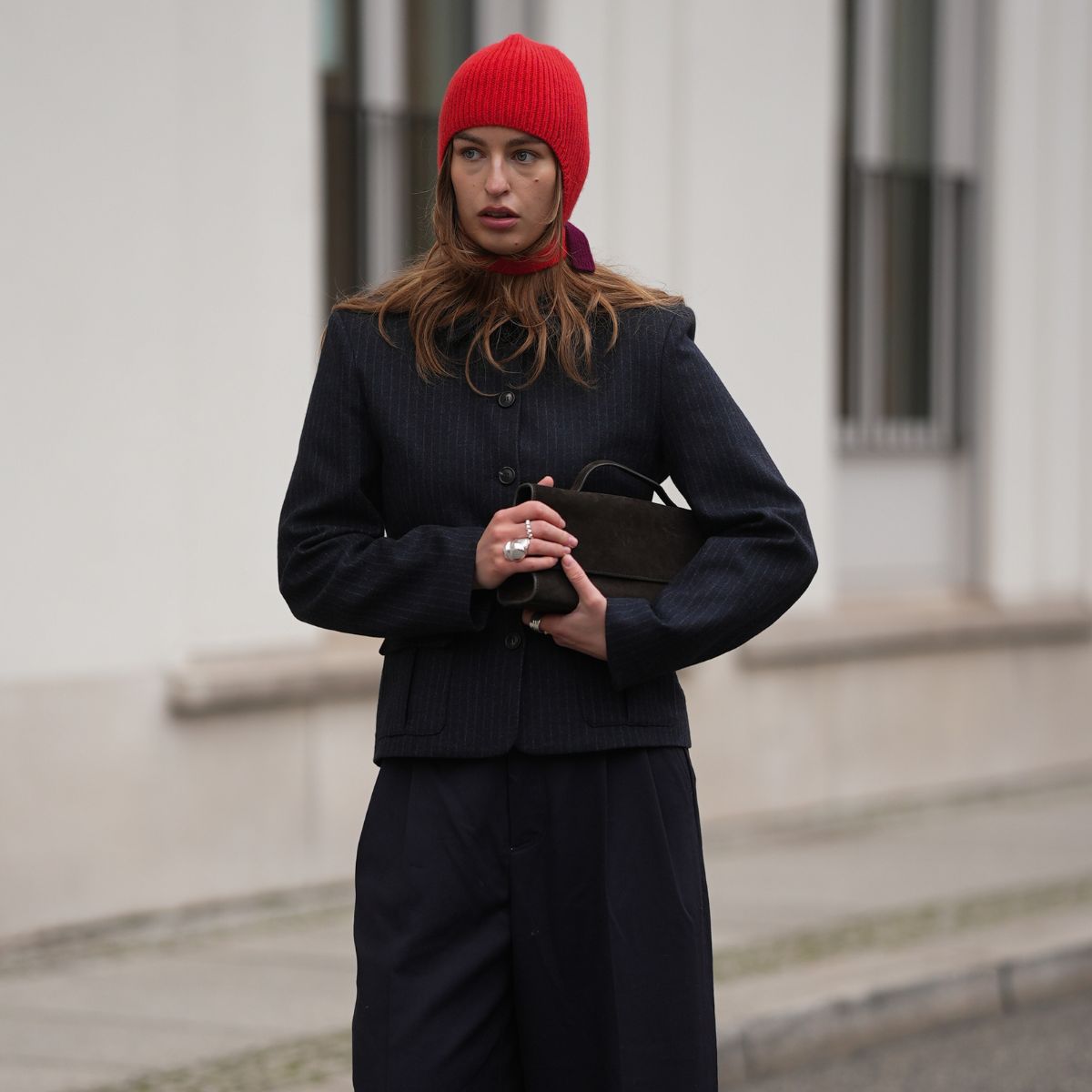 a model wearing a red cashmere bonnet and navy suit