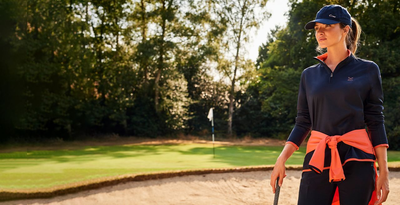 Female golfer wearing Crew Clothing's half zip sweatshirt