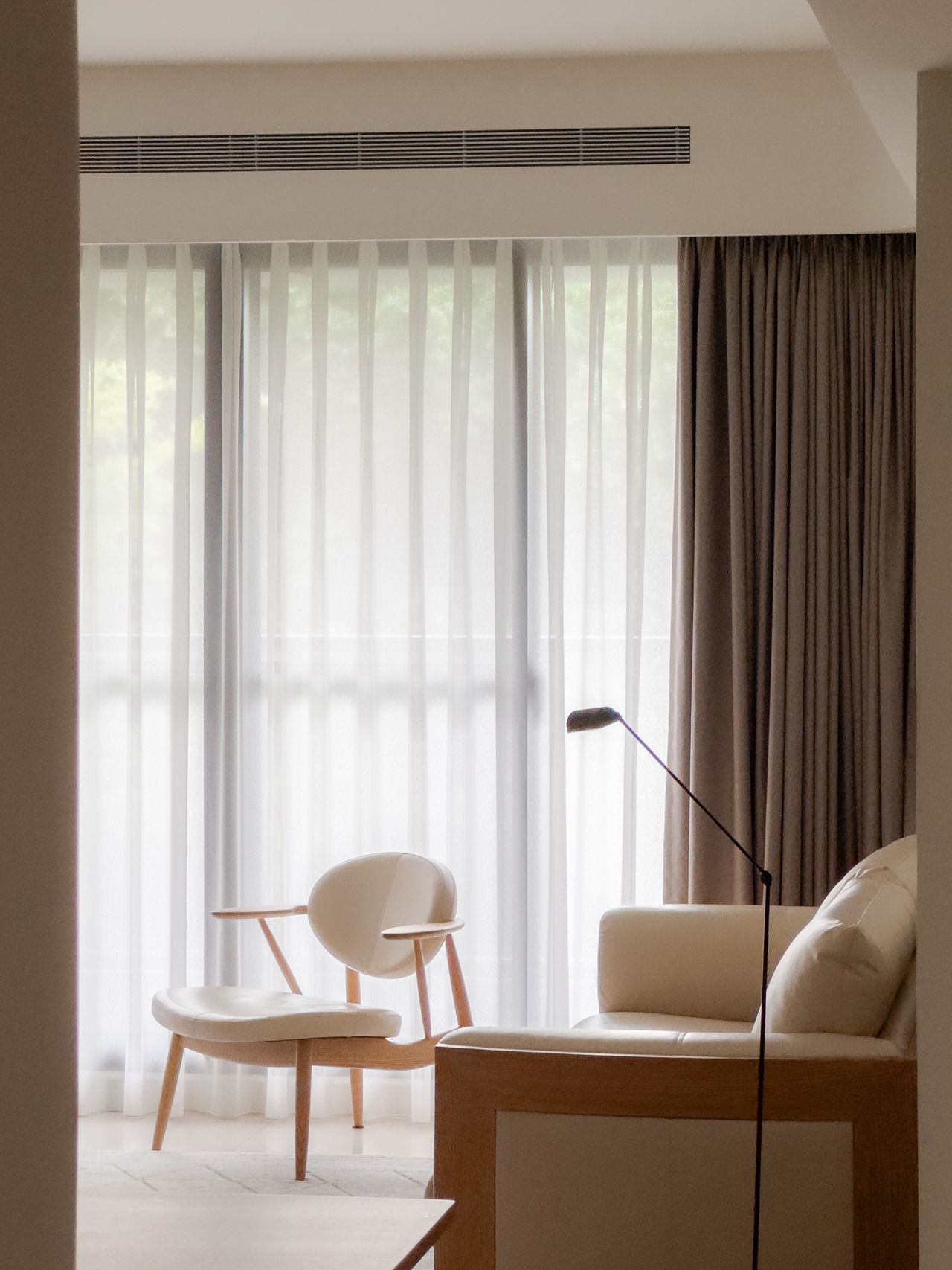 A small living room with muted interiors, a seating facing the TV