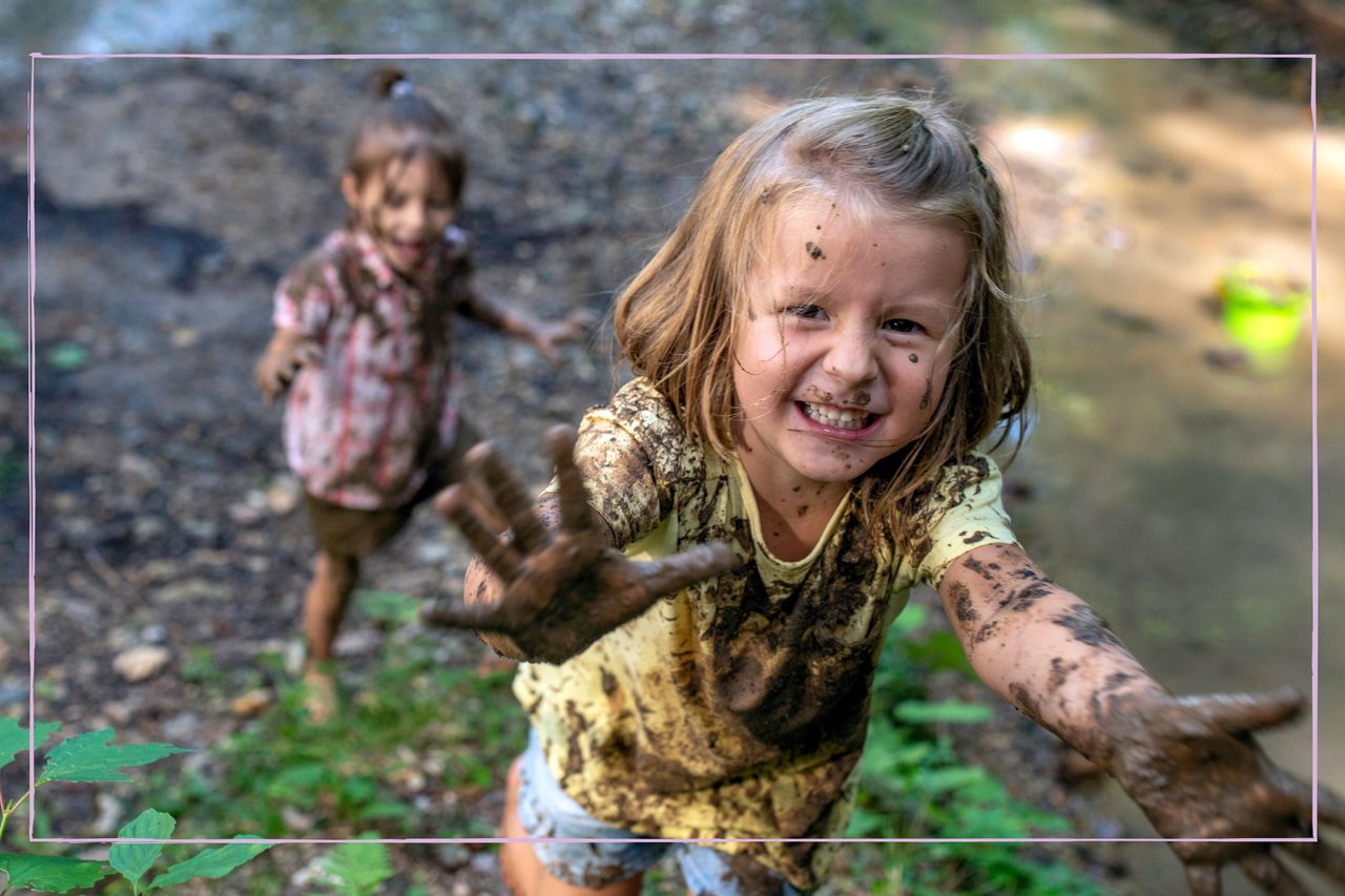 Smiling children engaging in messy play - they are covered in mud, playing outdoors