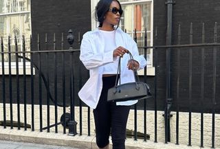 Woman wearing white button down with black capri pants.