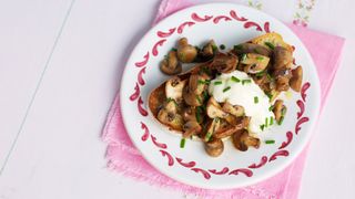 Mushrooms on toast with a poached egg on top displayed on a decorative plate