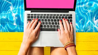 A woman types on a MacBook keyboard